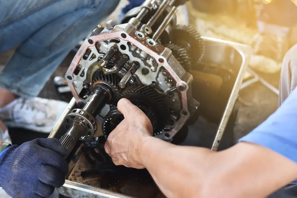 Mechanic checks and repairs the automobile transmission system